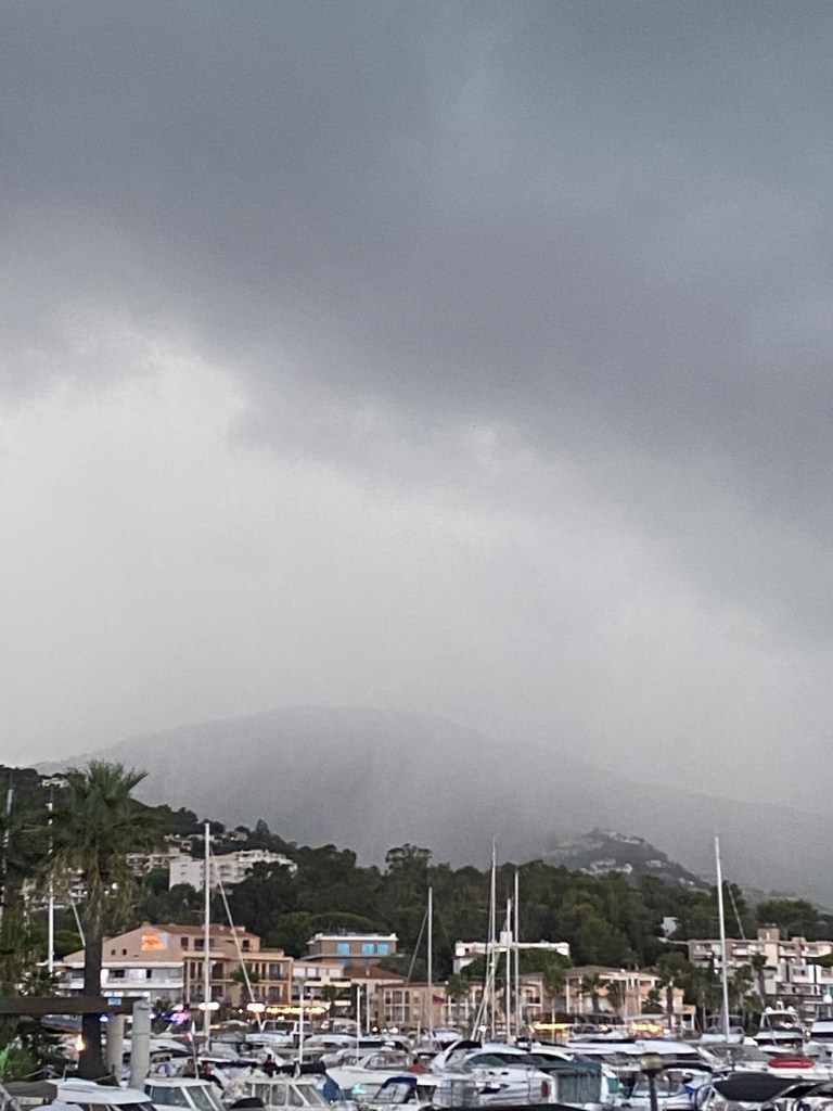 Une belle pluie orageuse est en train de s'abattre sur les bateaux de plaisance de la marina du port de Cavalaire