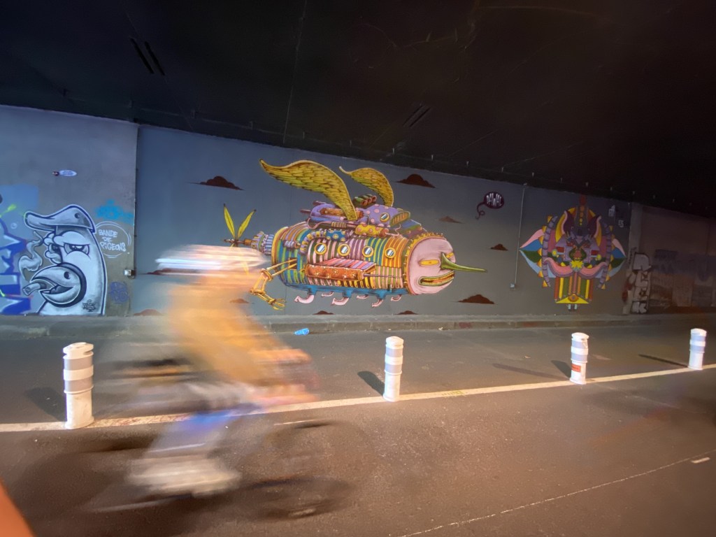 Un vélo me double sur ma auche dasn le tunnel des Tuileries bordé de fresques totalement irréelles, voire oniriques. Elles sont hautement colorées et cela ne manque pas de surprendre par le bon niveau artistique.