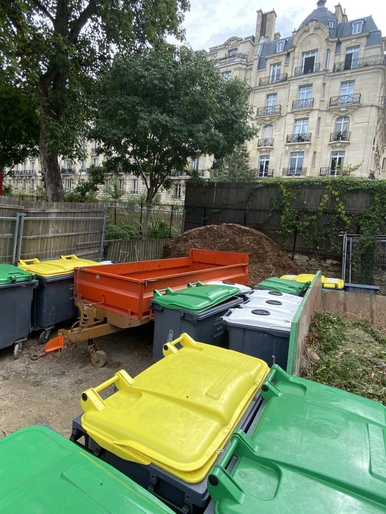 On aperçoit les couvercles colorés des bacs a compost