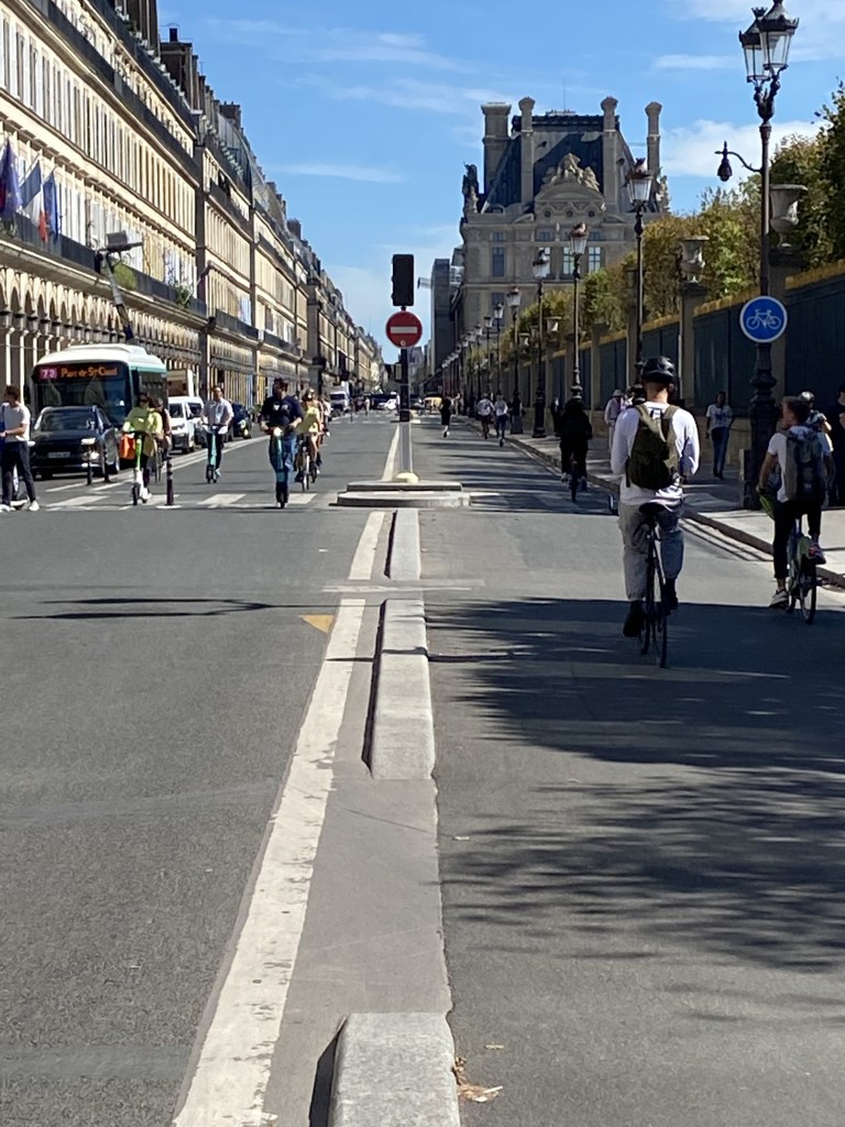 La belle perspective de la rue de Rivoli sous un soleil de fin d'été à Paris, sans aucune voiture. Seuls de nombreux vélos y circulent, colorés et silencieux.