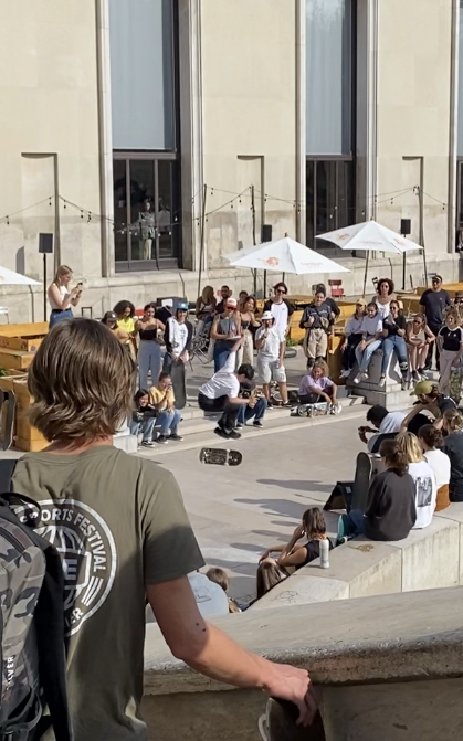 Des garçons s'amusent assez sportivement à se défier par des sauts en skate sur l'esplanade basse du palais de Tokyo