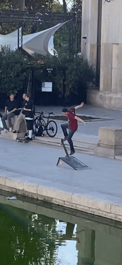 Des garçons s'amusent assez sportivement à se défier par des sauts en skate sur l'esplanade basse du palais de Tokyo