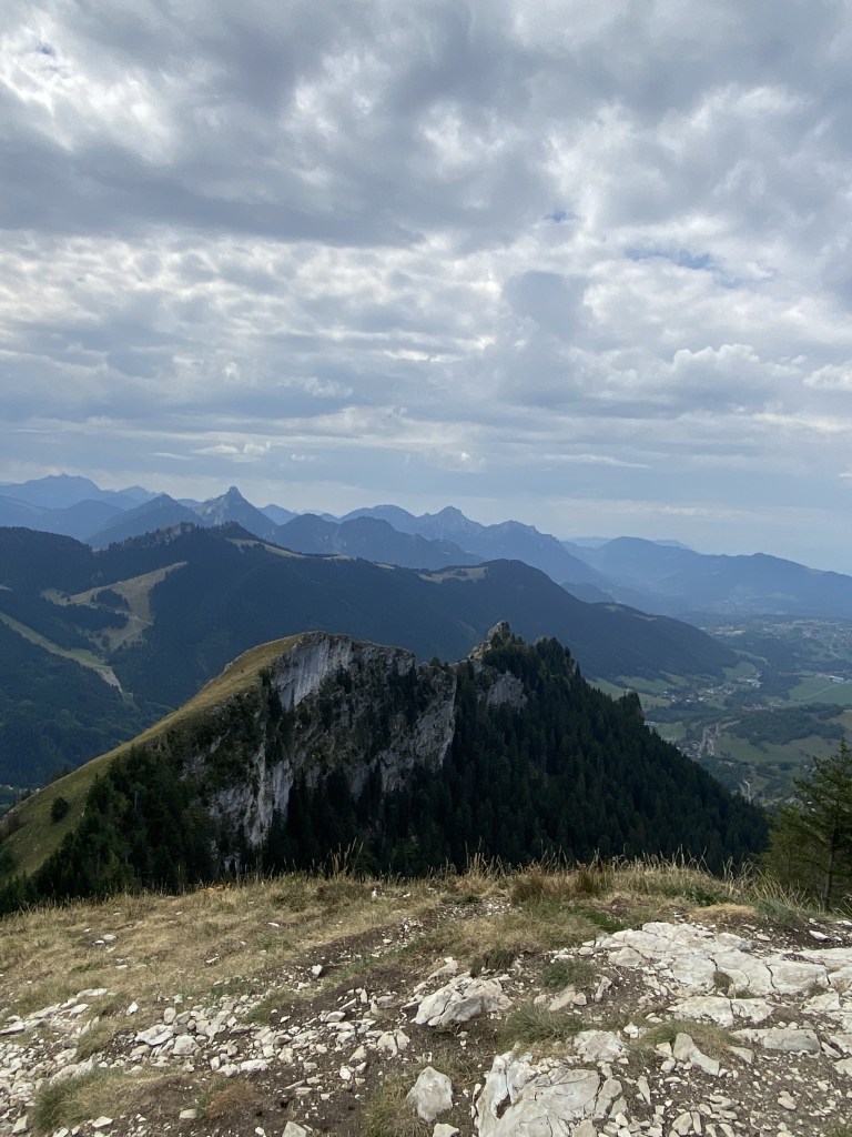 Sous un ciel nuageux, teinté d'un camaëu de gris, on voit au loin se découper le masif du Cahblais.