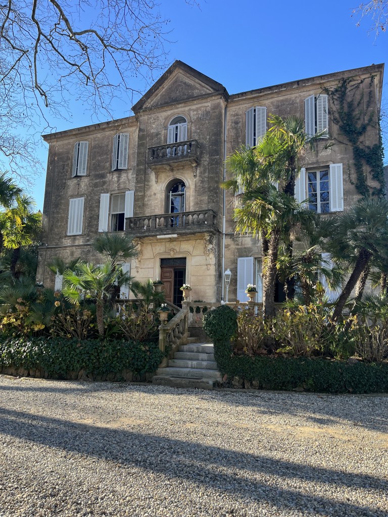 Une belle façade de style Napoléon III, avec des bouquets de palmiers devant la Grande Terrasse;