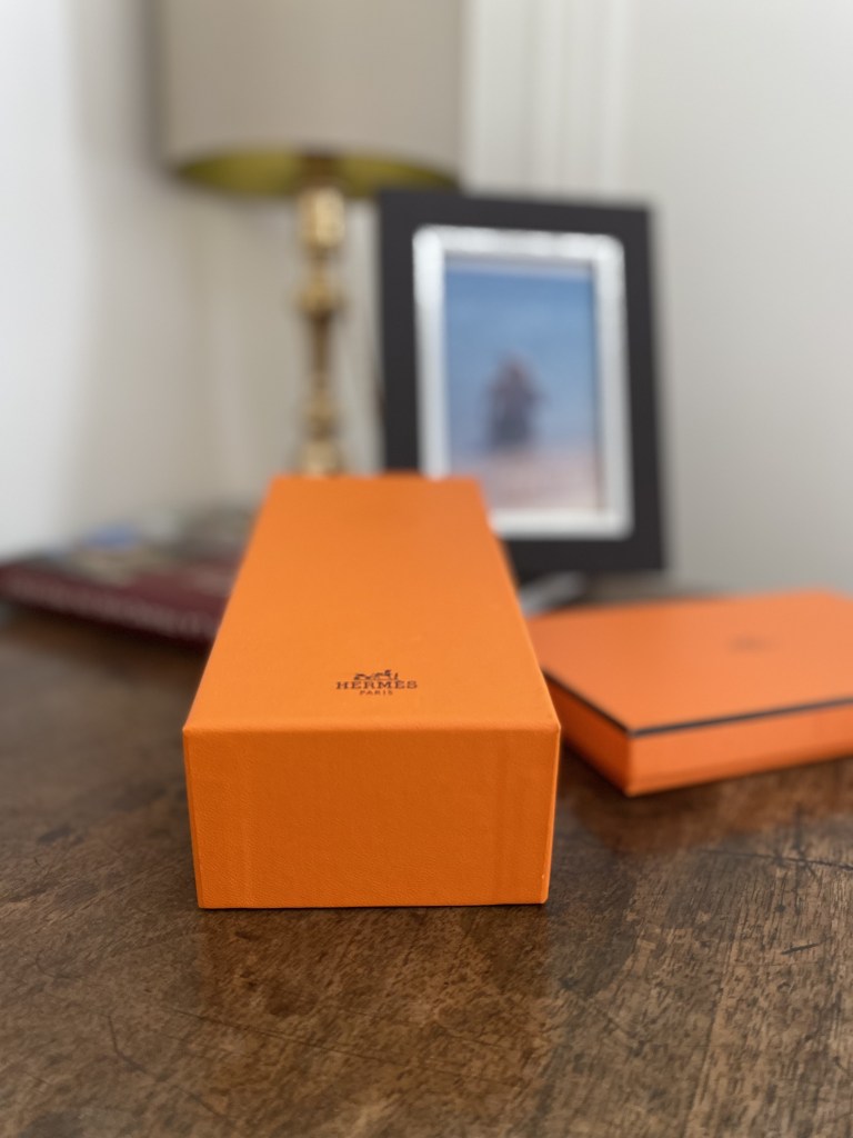 Gros plan sur des boîtes oranges de la Maison Hermès.