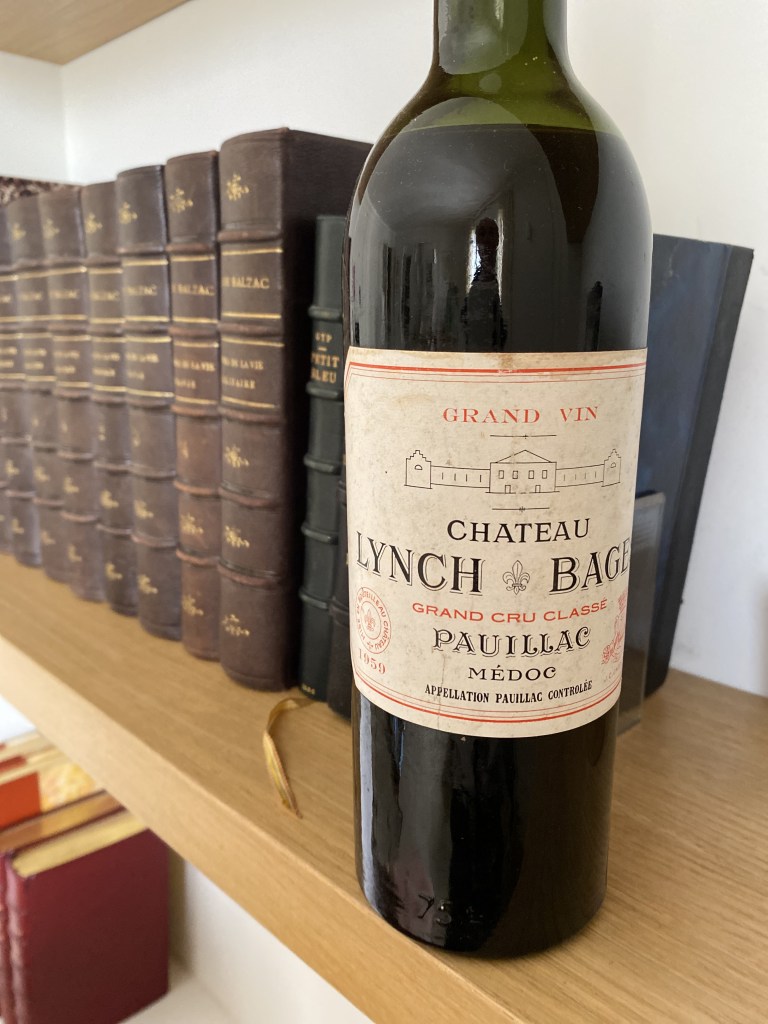 Très ancienne bouteille au milieu de livres anciens. Flacon de Lynch Bages 1959, Pauillac, Cinquième Cru au classement de 1855