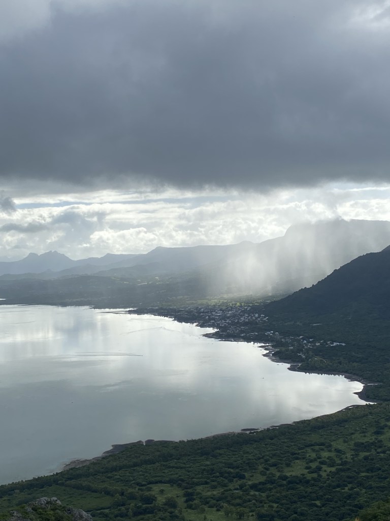 Une large vue plongeante, depuis la hauteur du Morne Brabant, sur une mer et un ciel gris, baignant la petite ville de La Gaulette