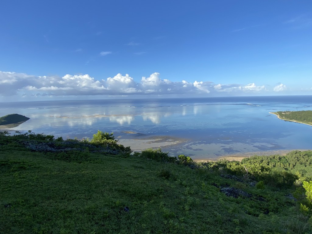 Une vue lumineuse sur la mer et la mangrove depuis le village du Morne à l'Ile Maurice, avec de beaux reflets de nuages